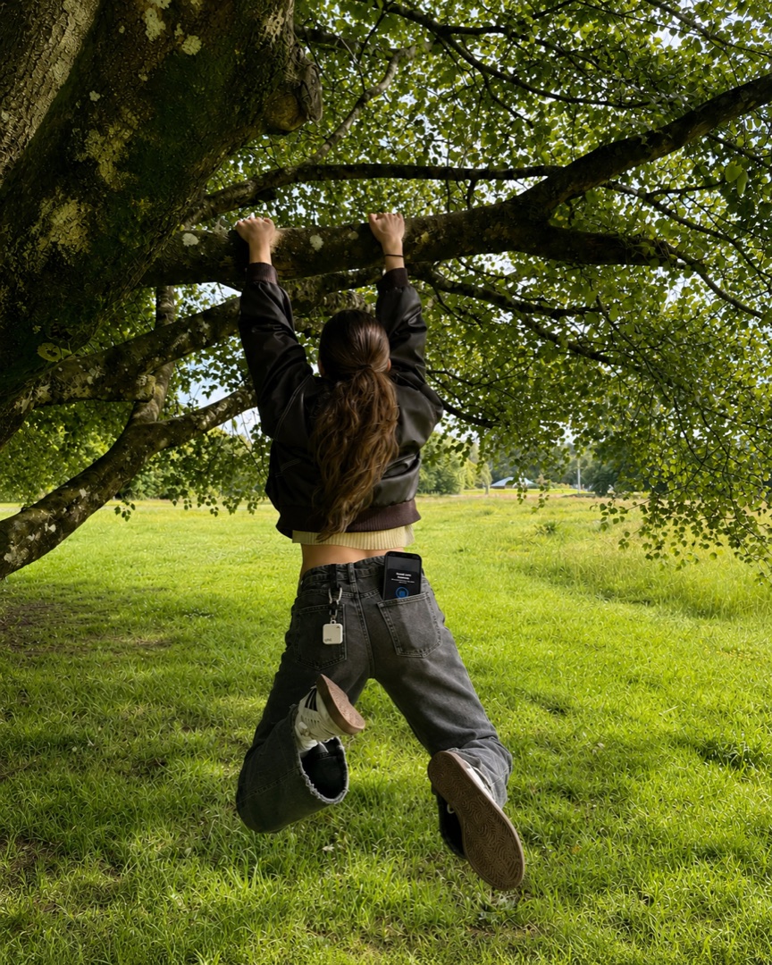 Person klettert an einem Baum, Key an der Jeans